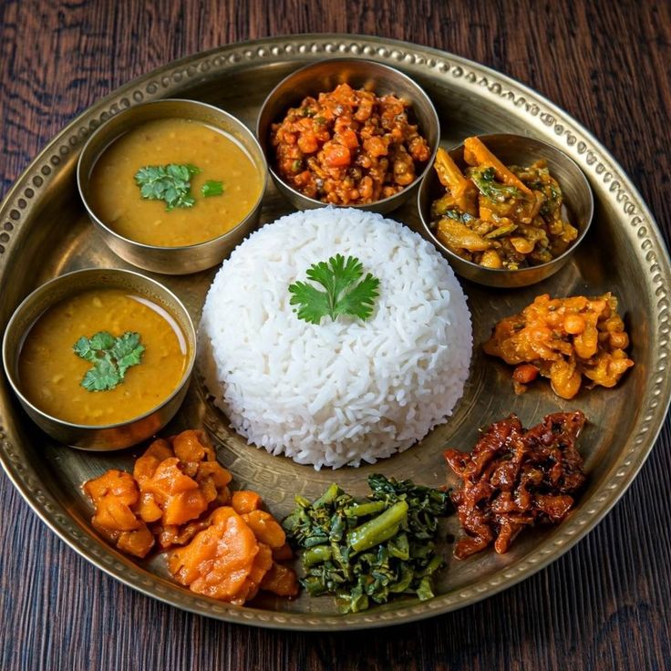 Nepali khana set thali with rice, dal, curries and pickles on a brass plate